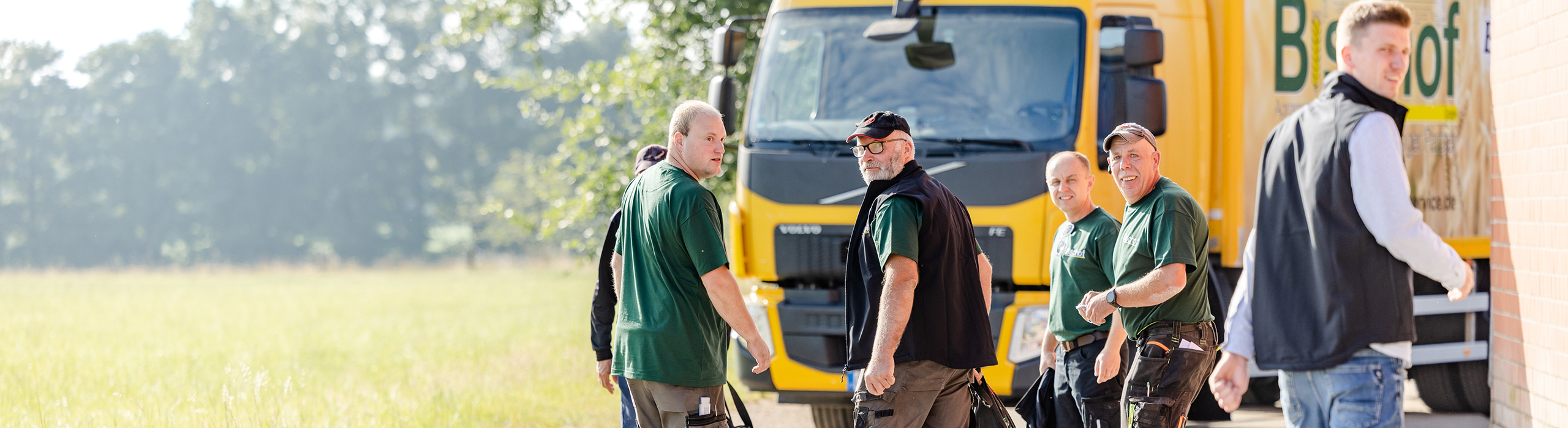 Das Team von Bischof vor Firmenfahrzeugen – Ihr Futtermittelexperte aus Dissen, Schüttorf & Warburg